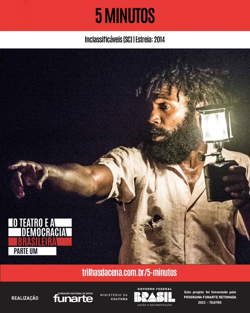 Um homem negro barbudo com uma lanterna e uma expressão feroz, estica seu braço e aponta seu dedo para algo fora do quadro da foto. O fundo é escuro. O texto diz 5 Minutos e O Teatro e a Democracia Brasileira - Parte Um. Vários logotipos estão na parte inferior.